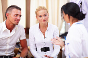 A couple receiving their test results from a doctor