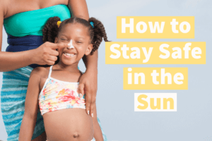 A mother applying sunscreen to her daughters nose