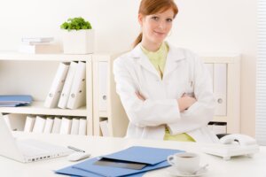 Medical files on a desk being looked over by a doctor